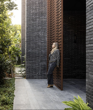Interior designer Dana Oberson beside a brick facade